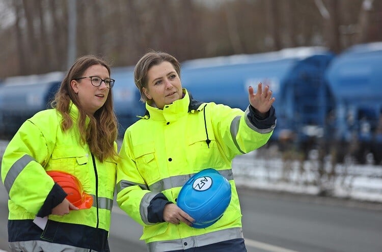 Zwei Logistik Mitarbeitende vor einem Güterzug
