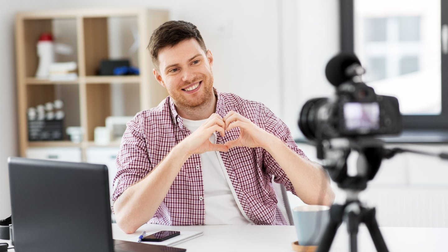 Ein Social Media Manager dreht ein Video am Schreibtisch
