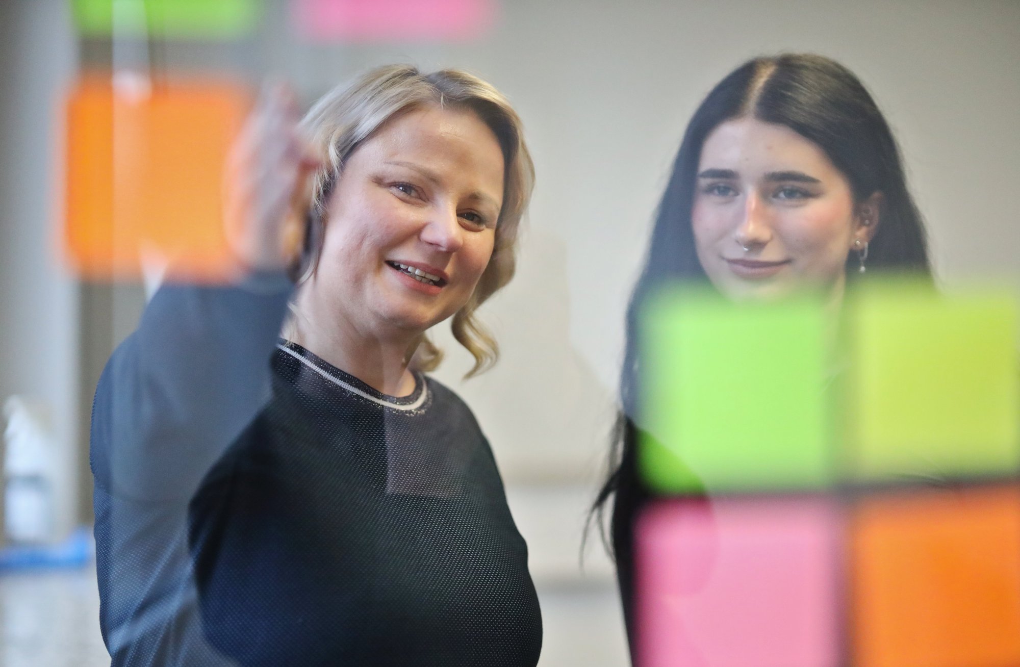Brainstorming zweier Personen mit Klebezetteln.