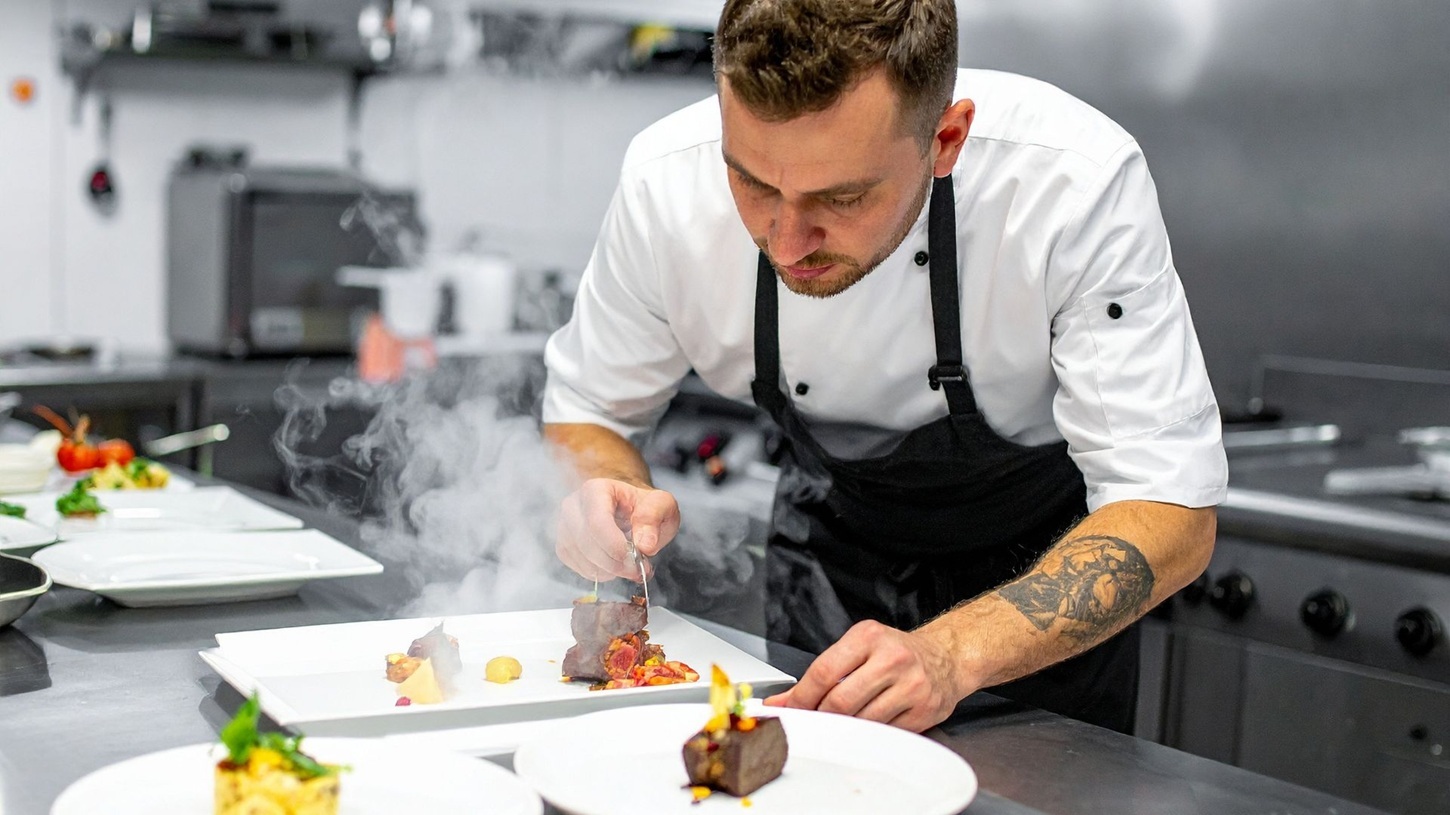 Koch beim Anrichten eines Gerichtes